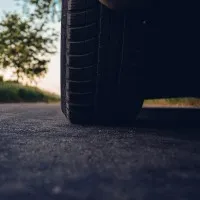 A black tire on a paved driveway